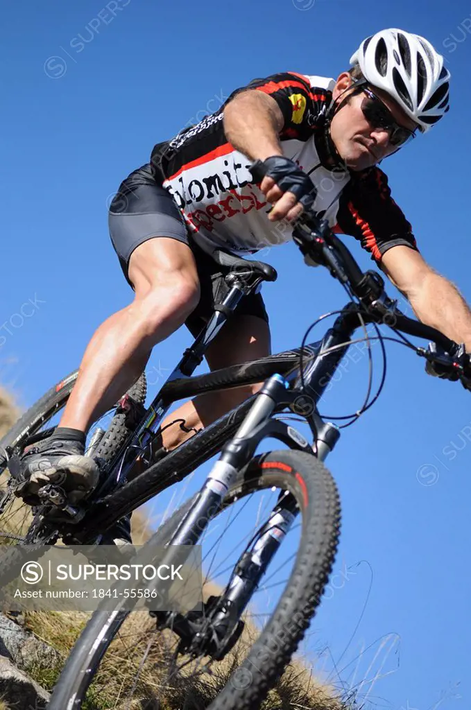 Male mountainbiker riding downhill, low angle view