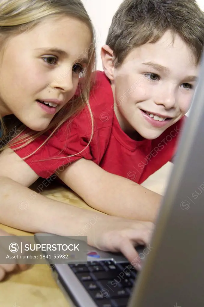 Boy and girl using laptop