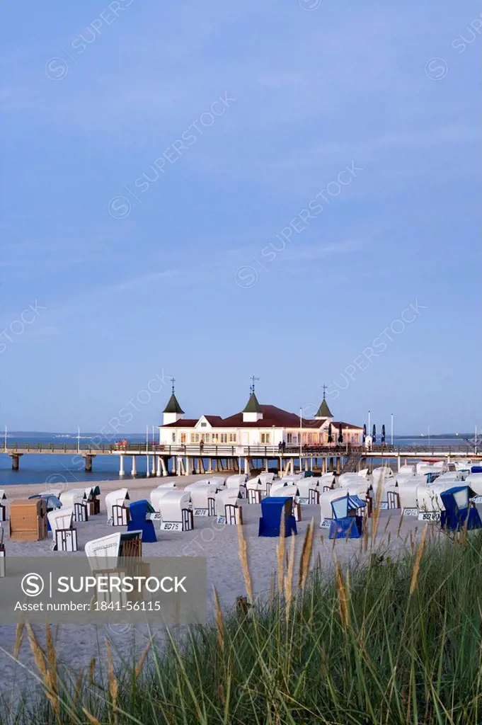 Hooded beach chairs on beach with pier in background, Ahlbeck, Usedom, Mecklenburg_West Pomerania, Germany