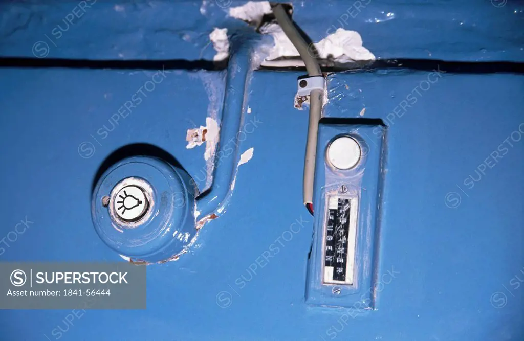 Close_up of peeling doorbell and light switch
