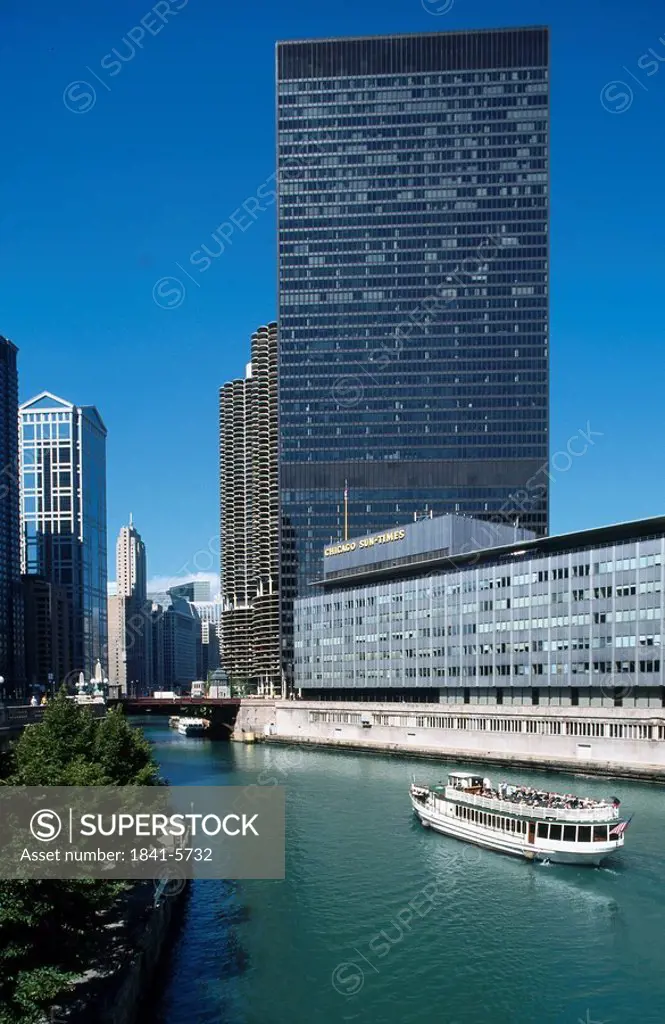Tourboat in river with IBM and Chicago Sun_Times buildings in city, Chicago, Illinois, USA