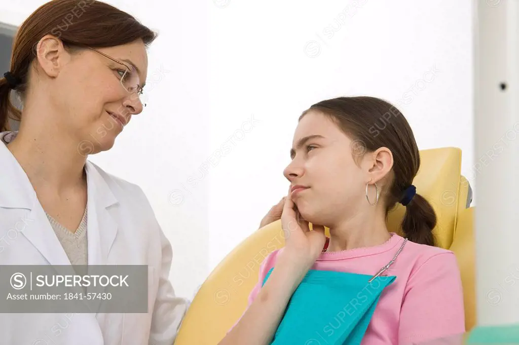 Female dentist and girl looking at each other