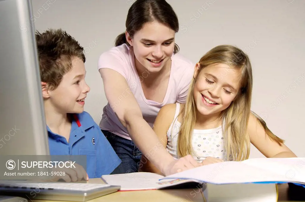 Brother and sisters studying and smiling