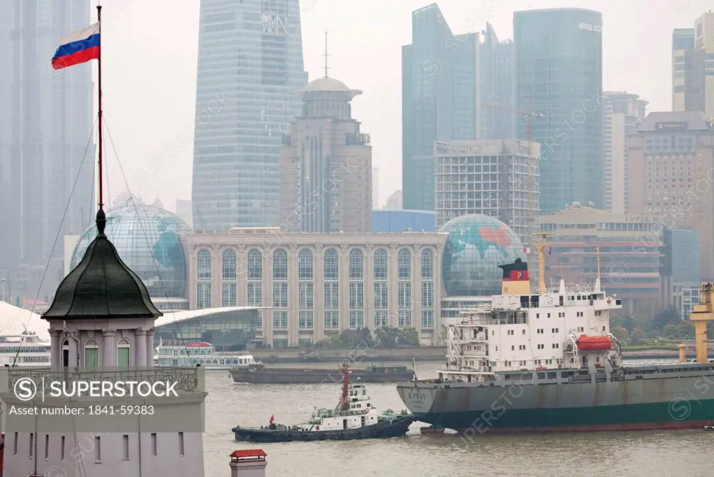 Ship and tugboat on a Huangpu River, Skyscrapers in the background, Shanghai, China, elevated view