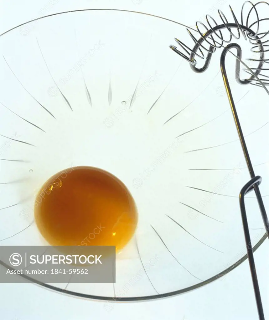 Close_up of egg yolk and wire whisk in bowl