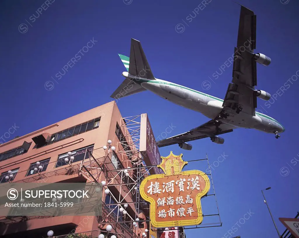 Low angle view of airplane flying over building, China