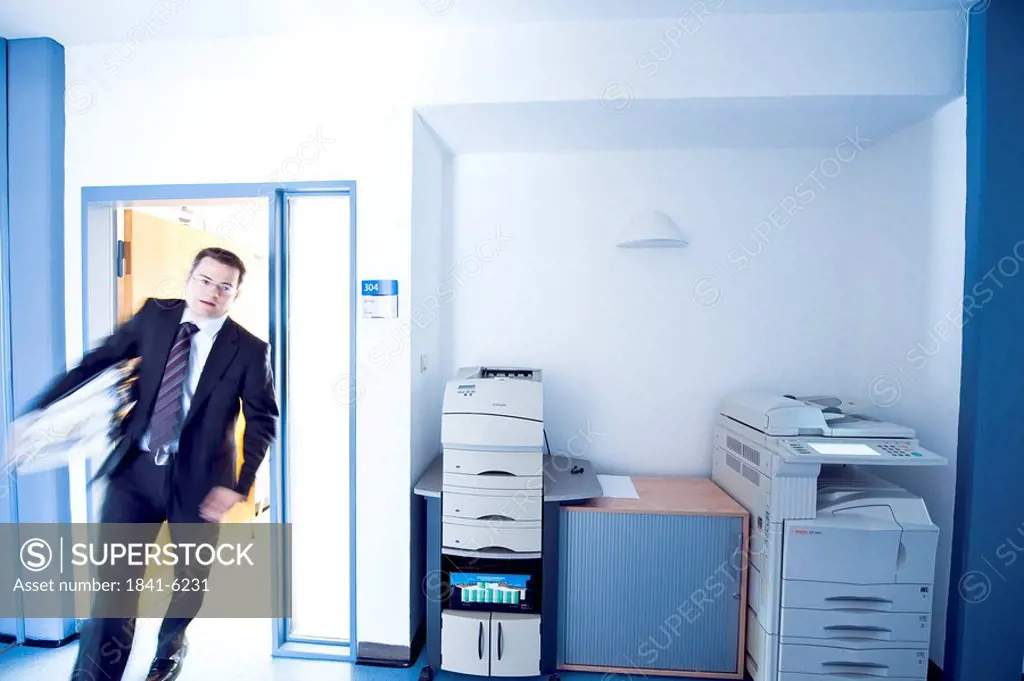 Overworked businessman entering a room, blurred motion, front view