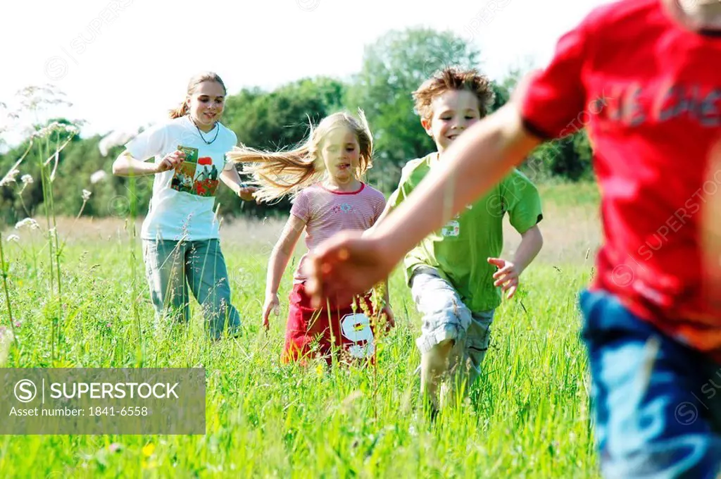 Children running over meadow