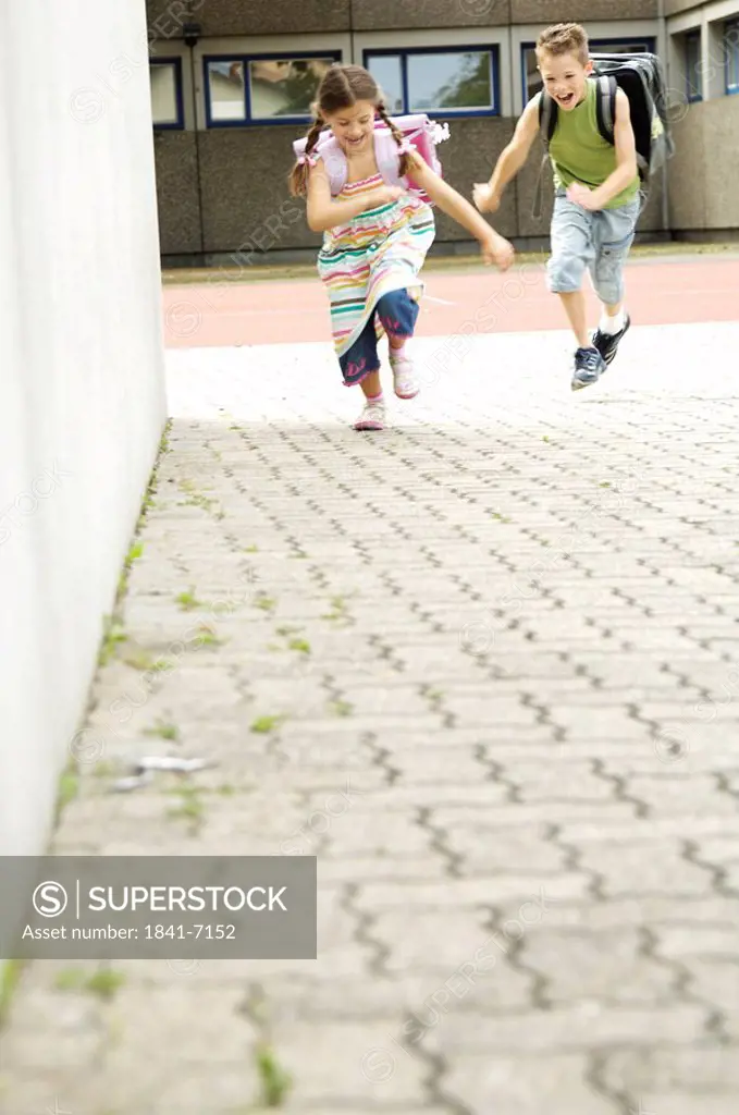 Boy and girl running on footpath