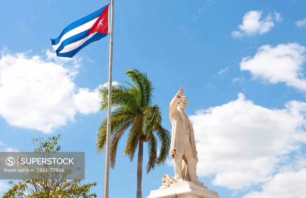 Cuban flag and statue in center of town of Jose Marti, Cienfuegos, Cuba
