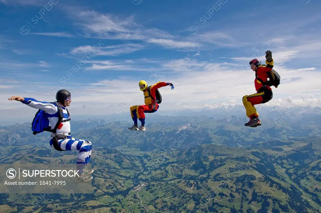 three people doing parachute jumping, full shot