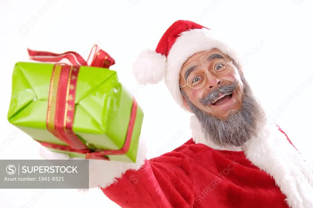 Portrait of senior man in santa costume giving Christmas gift