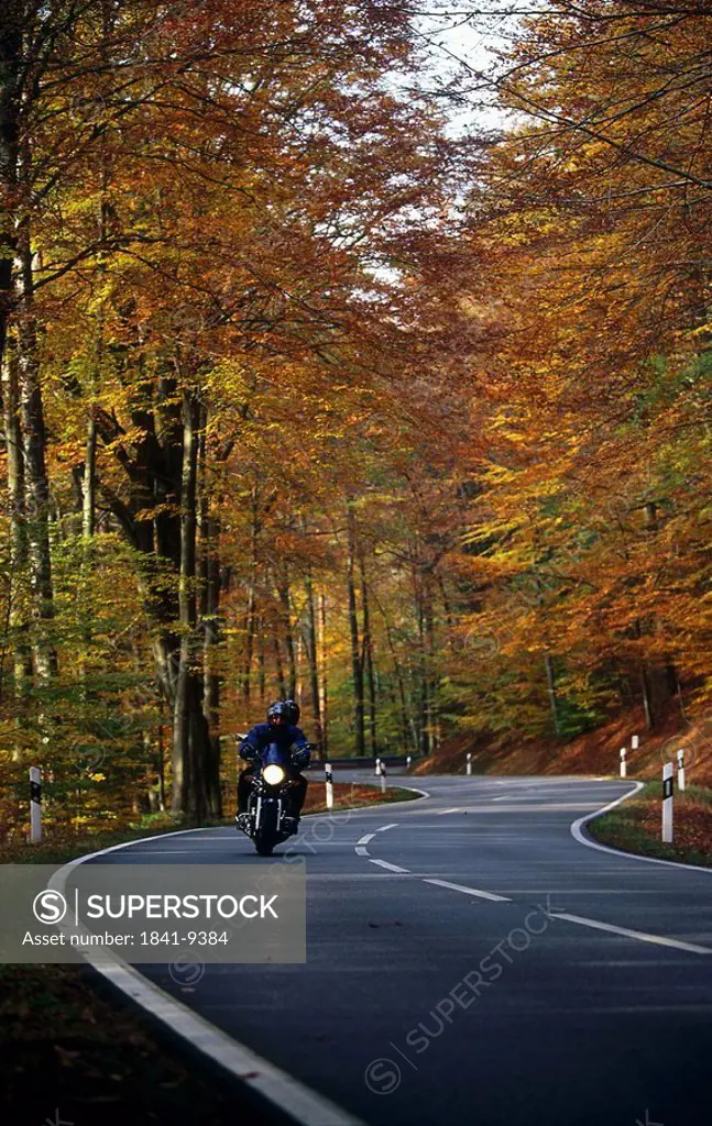 Person riding motorbike on road, Odenwald Forest, Germany