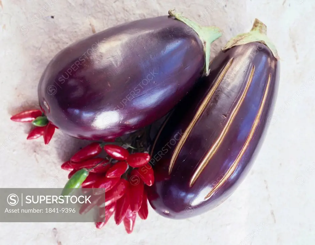 Close_up of aubergines with red chillis
