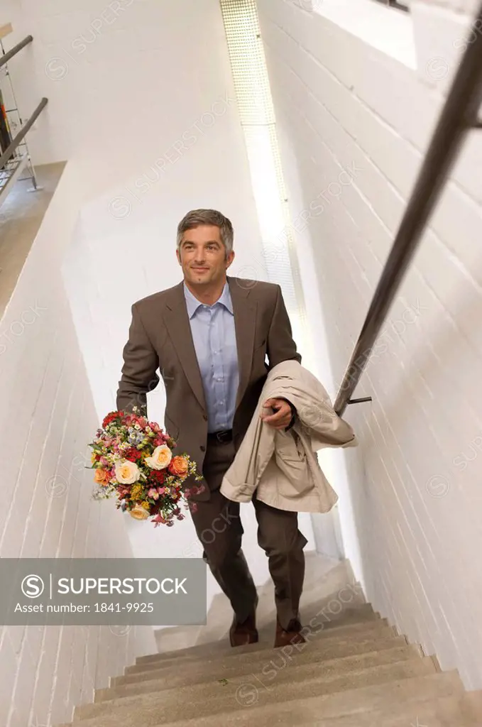 Man with a bouquet walking upstairs, elevated view