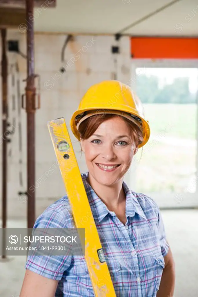 Woman with level and helmet