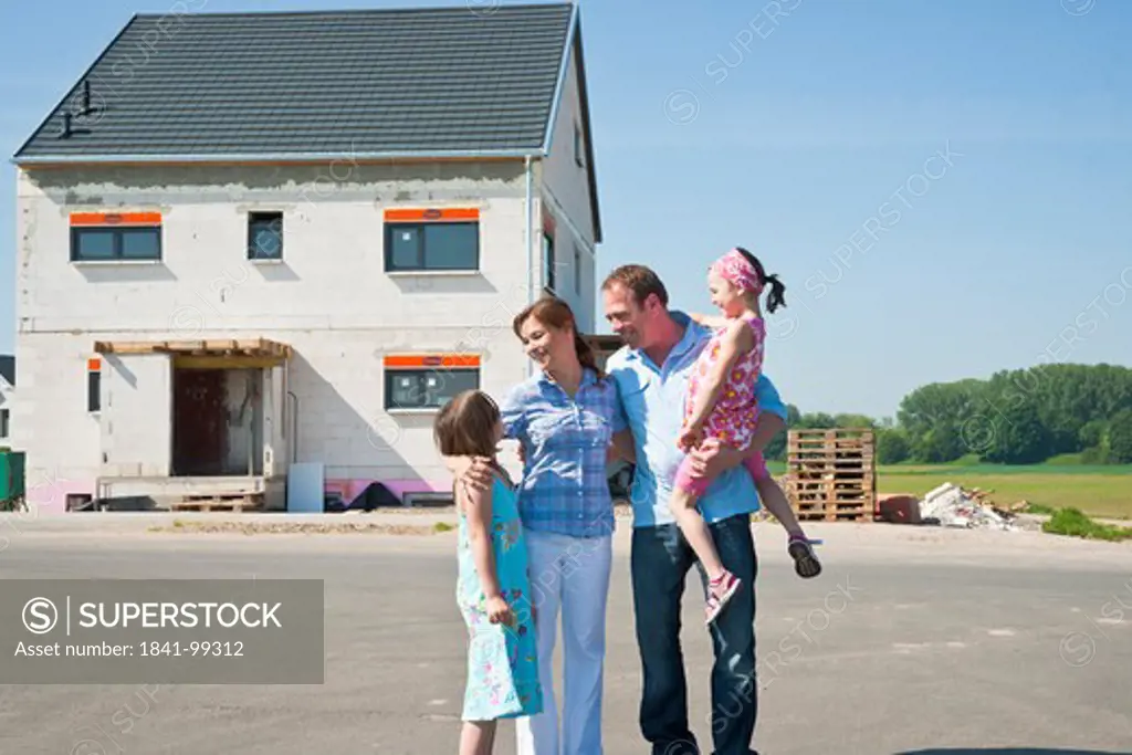 Family standing in front of shell of building