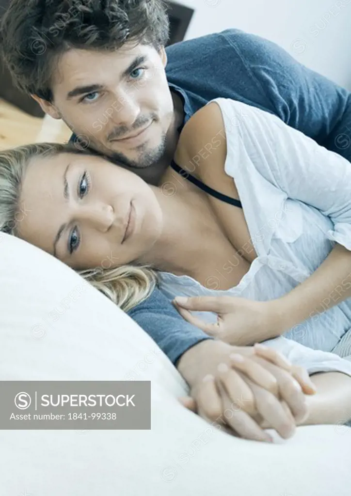 Affectionate young couple lying in bed