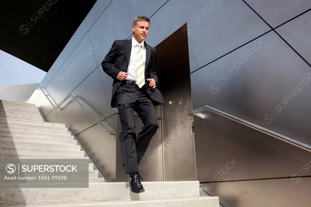 Businessman rushing down stairs