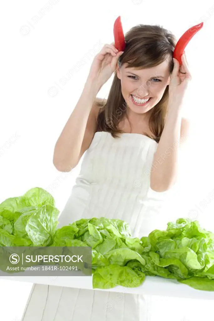 young woman with lettuce and chilli pepper