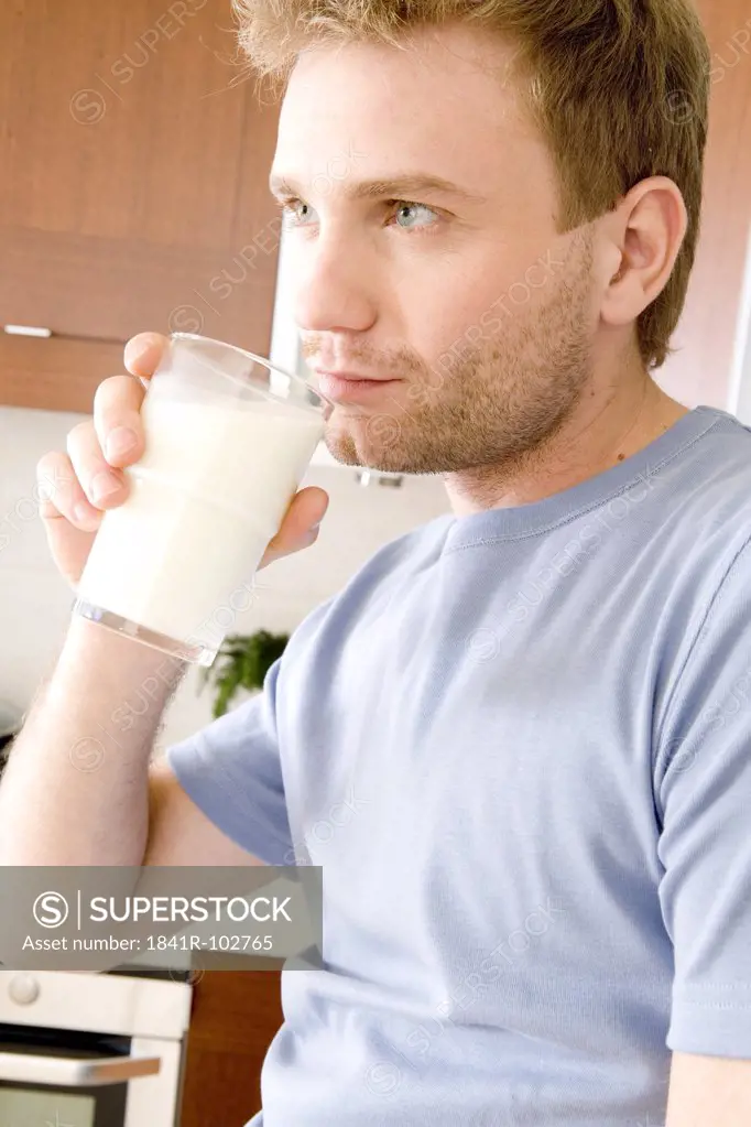 man drinking milk in kitchen