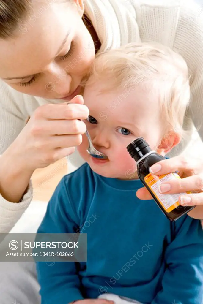 mum giving syrup to her child