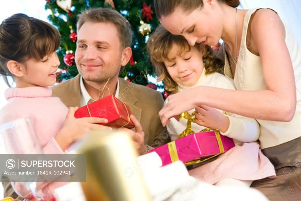 portrait of a family next to christmas tree