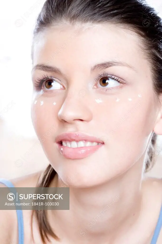 young woman puuting face cream