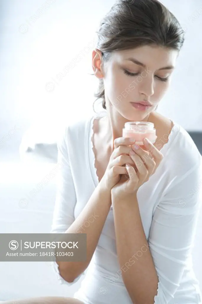 young woman holding cream