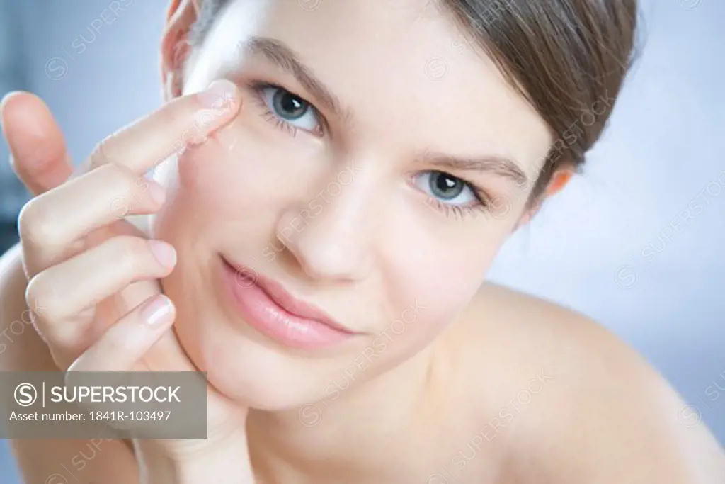 young woman applying face gel