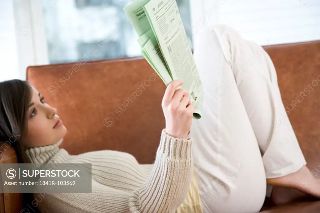 young woman reading newspaper