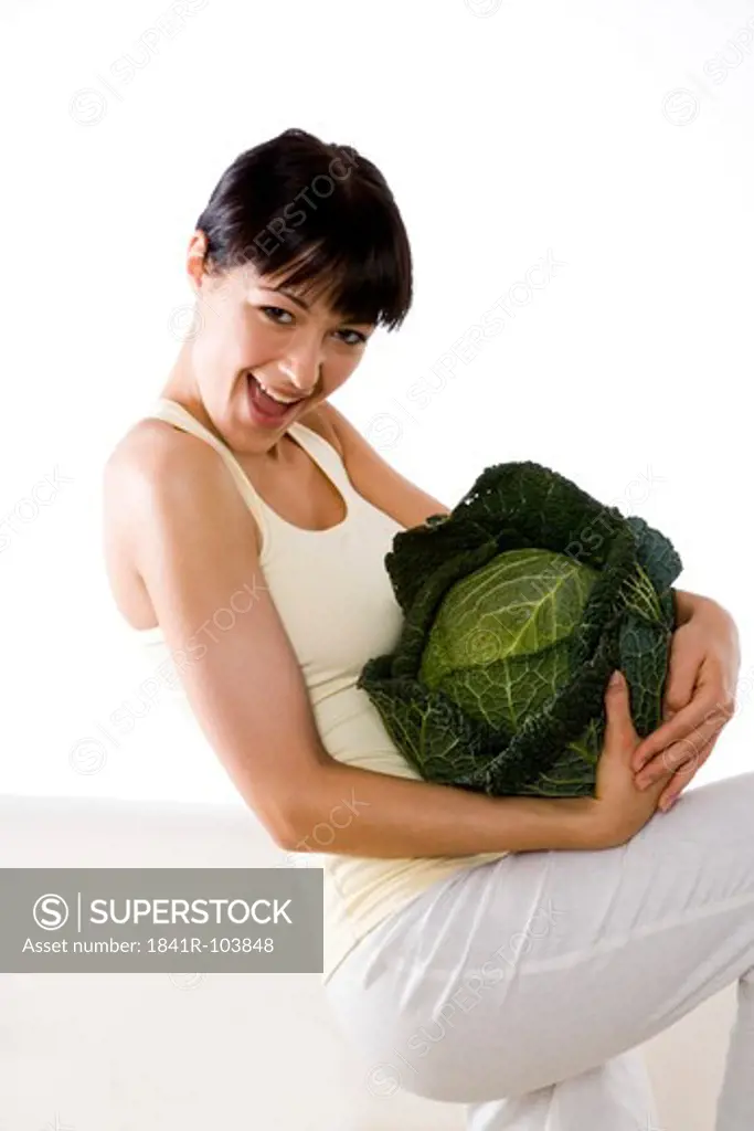 woman carrying whole green cabbage