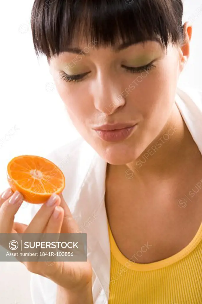 woman holding half of mandarine