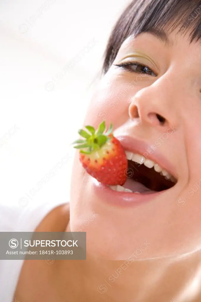 woman with strawberry in mouth