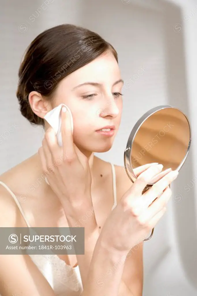 young woman cleaning her face