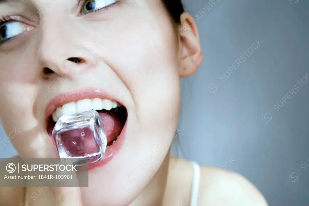 young woman with ice cube in mouth