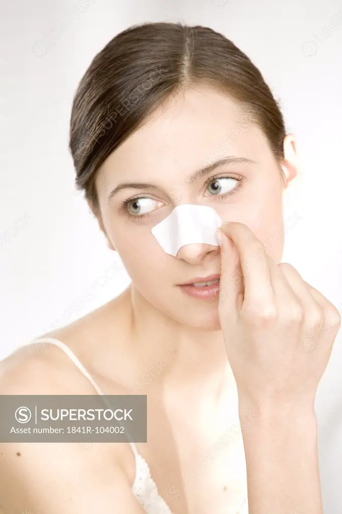 woman taking off cleansing strip