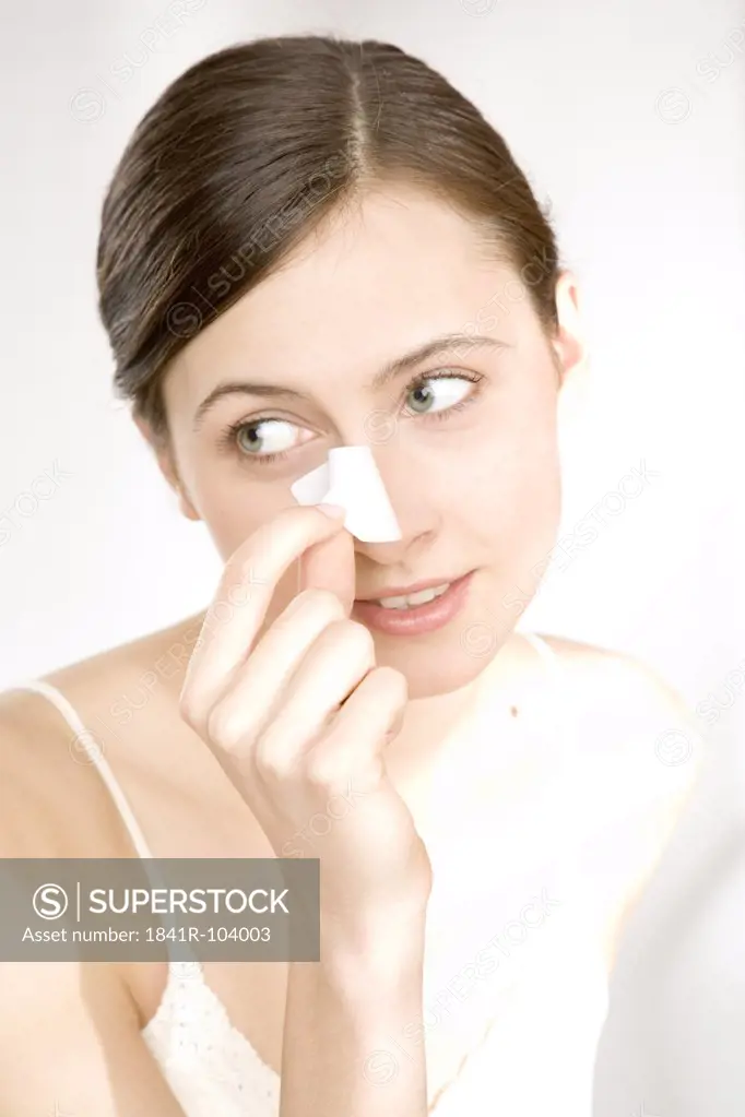 woman taking off cleansing strip