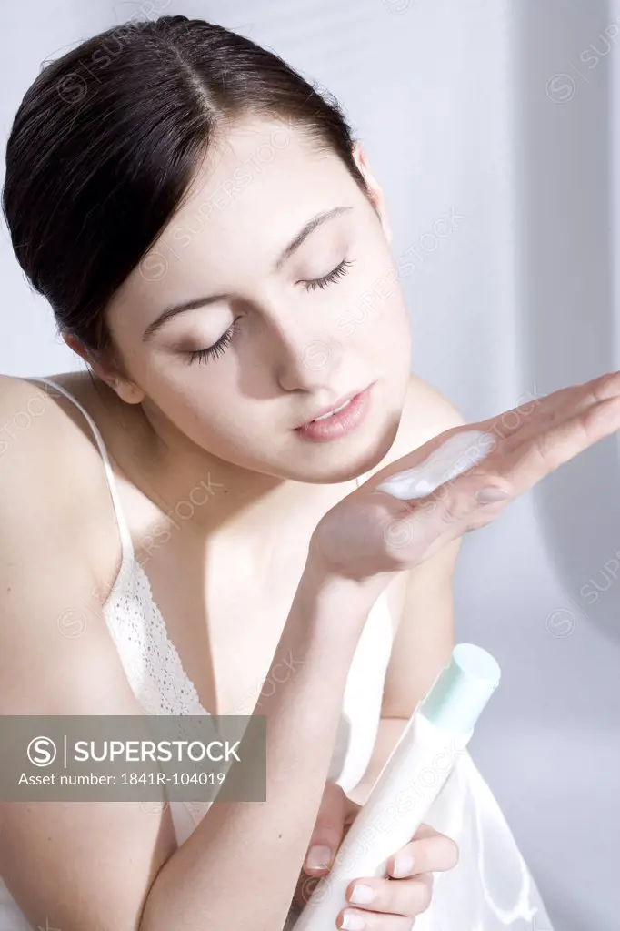 young woman iwth body milk on hand
