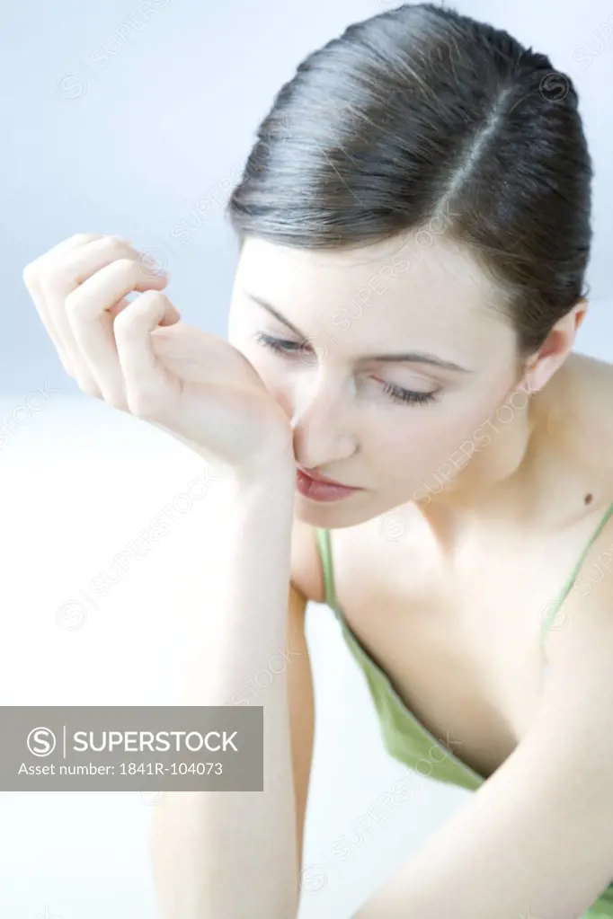 woman smelling perfume on wrist
