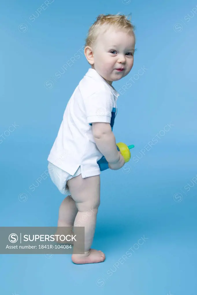 toddler standing with bottle in hand
