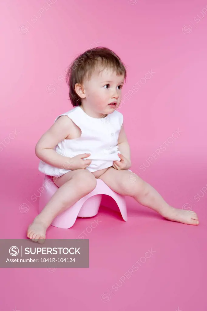 small girl sitting on her toilet