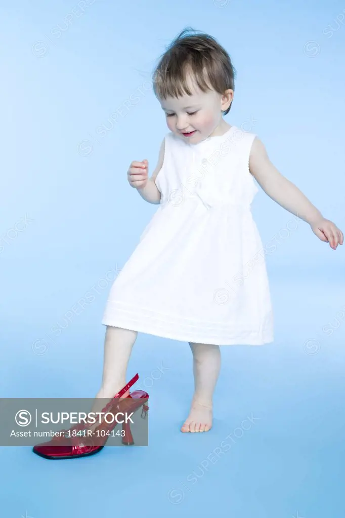 small girl trying on mother's shoes