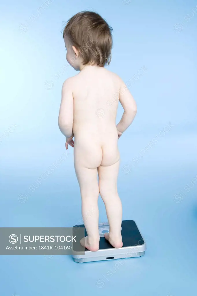 nude baby standing on scale