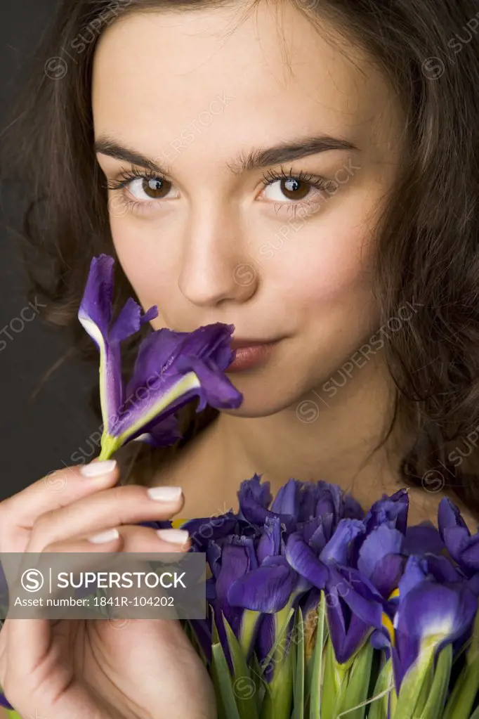 young woman smelling blue iris