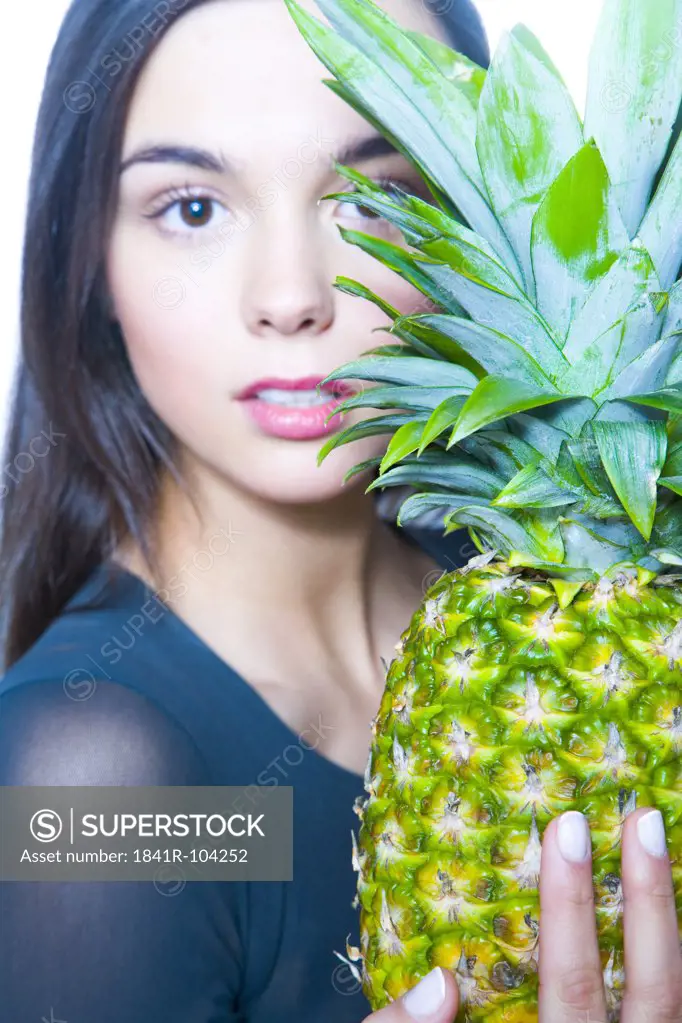 young woman holding pineapple