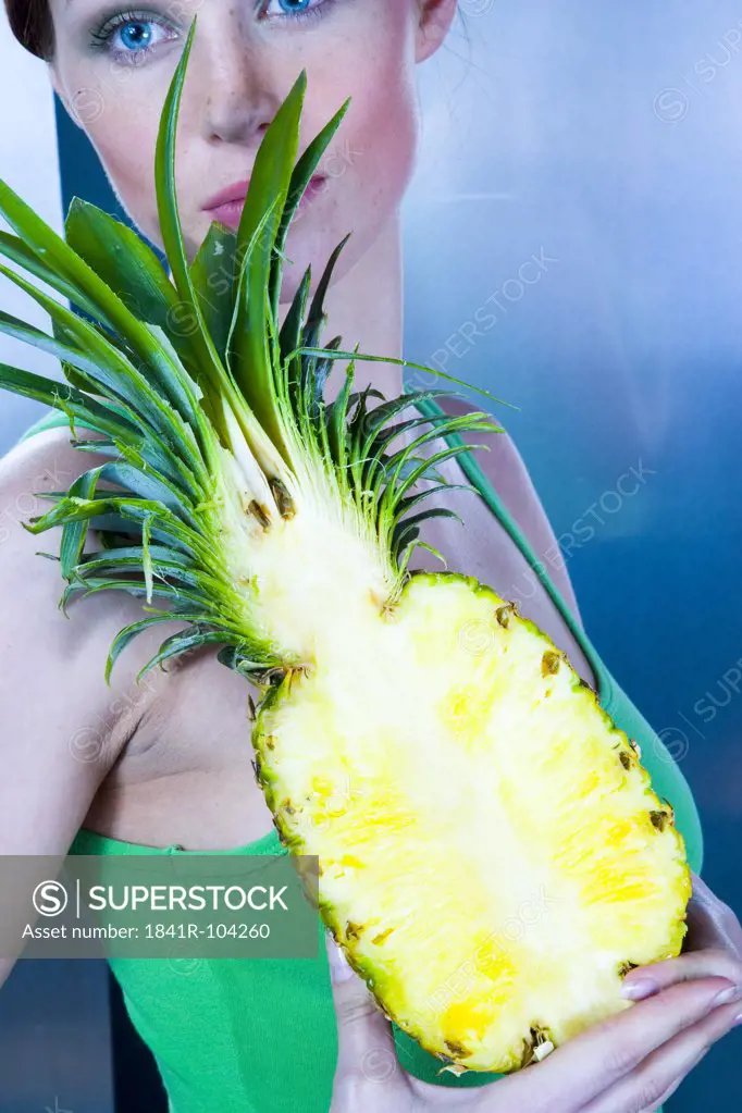 young woman holding pineapple