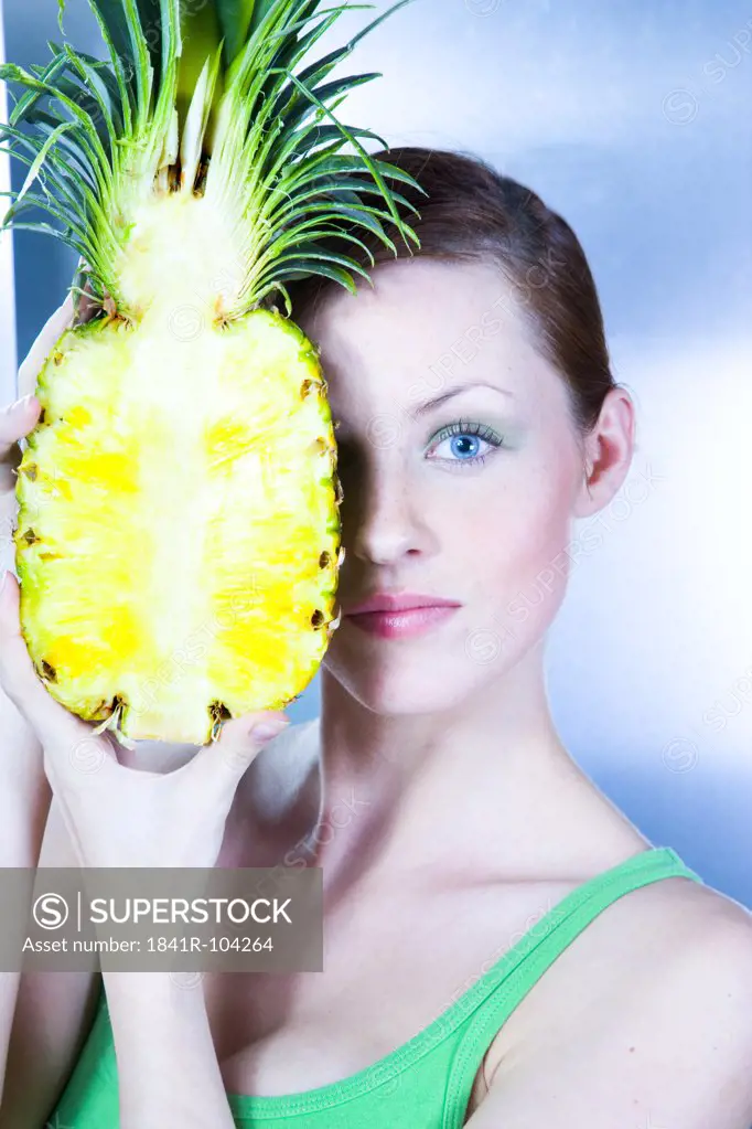 young woman holding pineapple