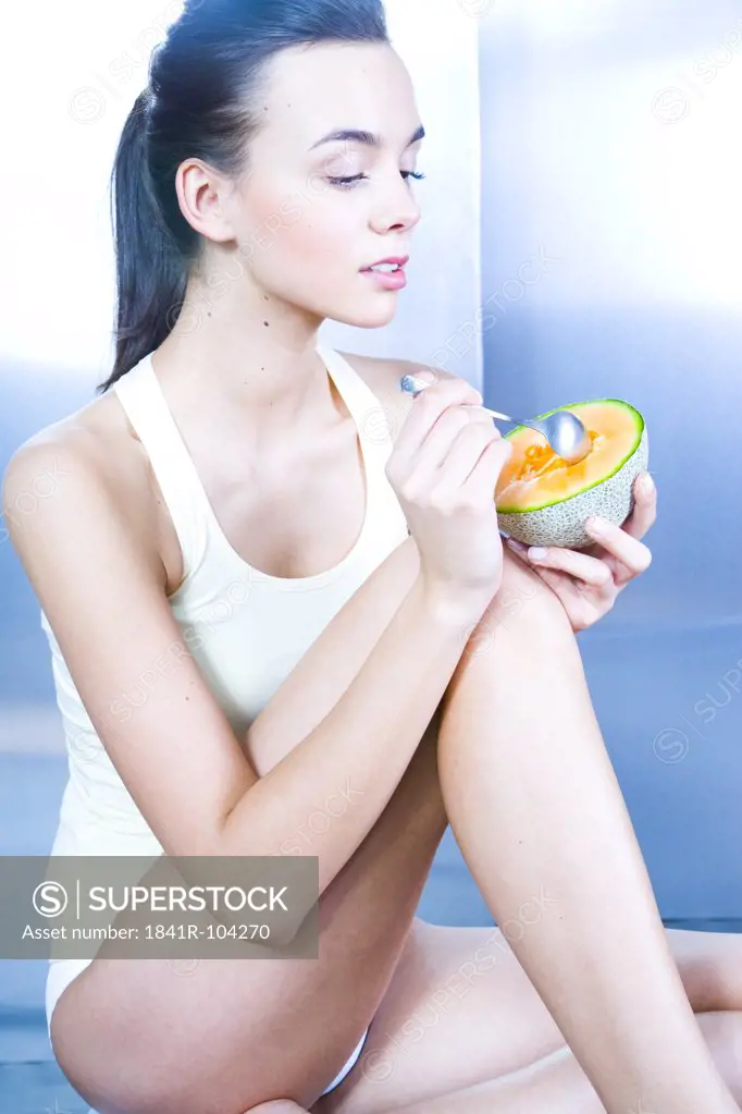 young woman eating melon