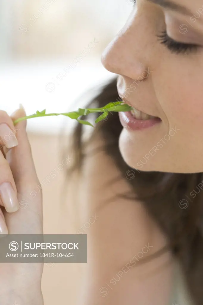 woman biting rocket leaf